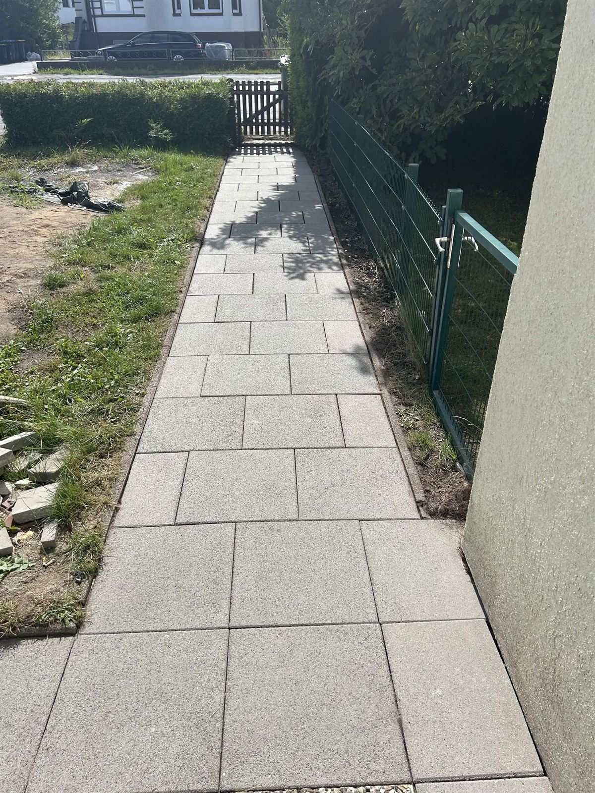 Derselbe Plattenweg nach der Reinigung, gleichmäßig hell und frei von Ablagerungen